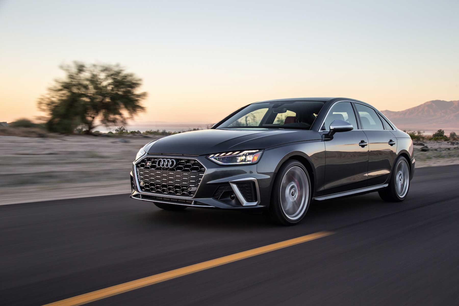 audi sedan driving down desert road
